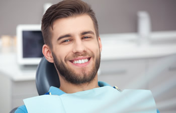 Smiling young man in the dental chair